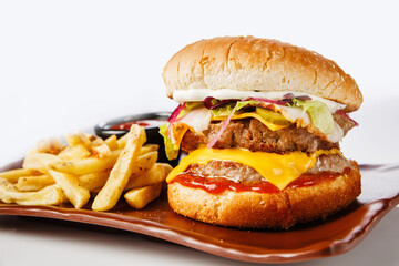 Burger. Juicy pork cutlet, cheddar cheese, crispy pickled onions, lettuce wrapped in a bun under two sauces. Served with french fries