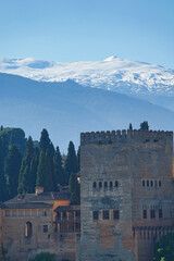 Vertical photograph of the Torre de Comares, the largest in the Alhambra in Granada, with Sierra Nevada in the background