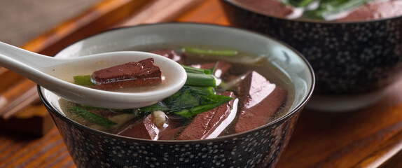 Eating Taiwanese traditional pig blood soup with pickled mustard greens.