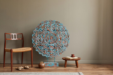 Stylish composition at moroccan interior with wooden mandala decoration, chair, stool, book and...