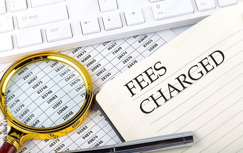 Poster fees charged text on notebook with chart, magnifier,keyboard and pen