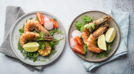 grilled tiger prawns with vegetables on a ceramic plate, top view