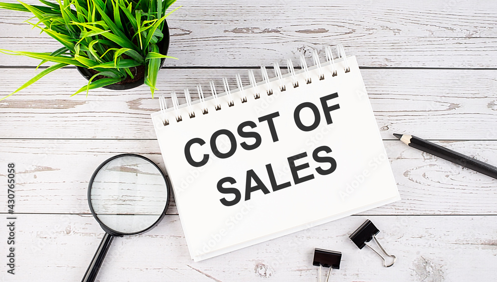 Aufkleber cost of sales text concept write on notebook with office tools on wooden background