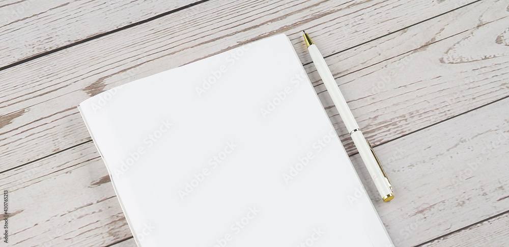 Poster top view of open blank notebook with pen on white desk background