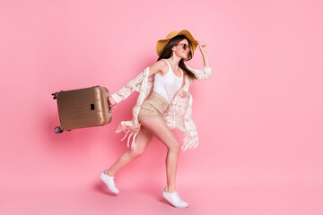 Photo of pretty sweet young lady wear lace cardigan cap smiling holding suitcase running isolated pink color background