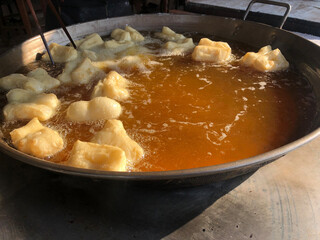 Closeup of fresh dough, oriental doughnuts frying in hot oil pan. Famous traditional asian breakfast food.