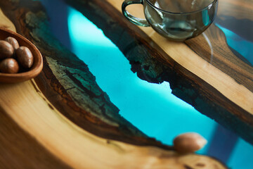 Close up of epoxy wooden coffee table with glass and nuts. Details. Texture.