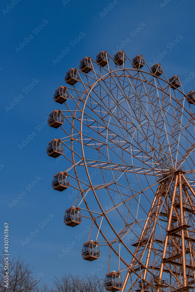 Wall mural ferris wheel on background of blue sky. attraction on sunny summer day. concept: weekend getaway wit