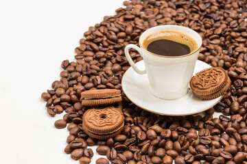 White cup of coffee with froth. Chocolate chip cookies on saucer