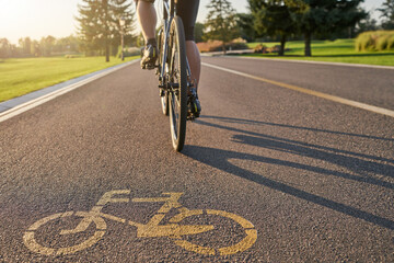 Place to train. Close up of a bicycle sign drawn on asphalt. Professional male cyclist riding a...