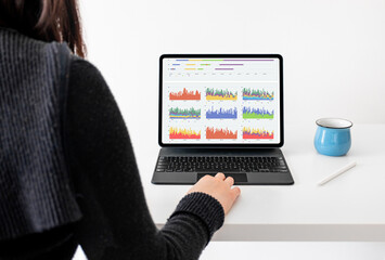 Young woman is reading charts on a tablet.