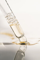 A drop of cosmetic oil falls from the pipette