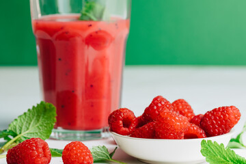 glass with red smoothie. Healthy eating and sustainability. Smoothie made from raspberries and other red fruits.	