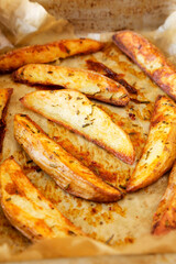 Homemade Rosemary Potato Wedges on a baking tray, side view.