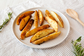 Homemade Rosemary Potato Wedges on a plate, side view.