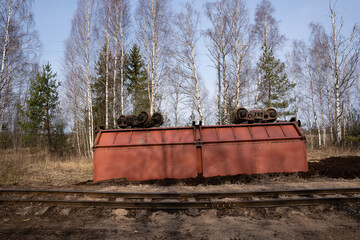 narrow gauge railway in a swamp where a wagon with peat overturned