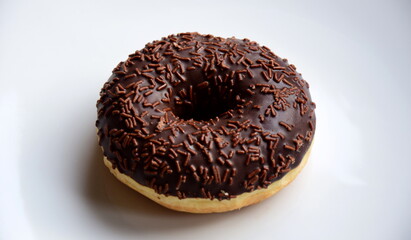 Donut mit Schokolade und Schokostreusel vor weißen Hintergrund isoliert	