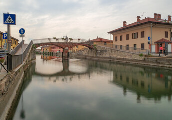 Bridge and colorful farmhouses on the ancient canal called Naviglio Grande in the countryside near Milan.Lombardy,Italy.