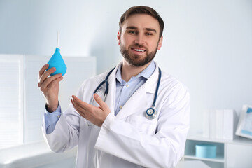 Doctor holding rubber enema in examination room