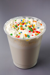 white milkshake with multicolored balls on a gray background