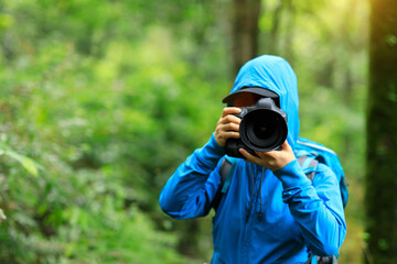 Fototapeta na wymiar Woman photographer taking photo in spring forest