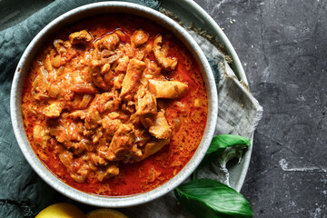 Traditional curry and ingredients. Tikka Masala chicken and rice. Indian food. Top view. Copy space. Dark background.