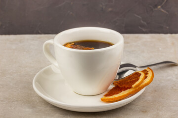 Cup of coffee on a neutral background with citrus chips