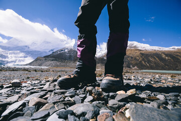 Woman hiker hiking in high altitude winter mountains