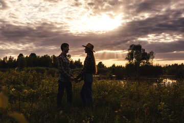 Loving couple in the field. Sunset, silouette.