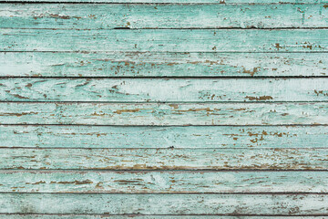 Old wooden wall made of boards as a texture. Green boards are arranged horizontally