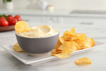 Potato chips and mayonnaise on white marble table