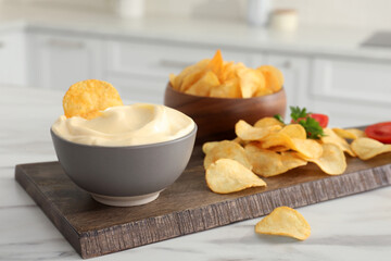 Potato chips and mayonnaise on white marble table, space for text