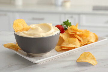 Potato chips and mayonnaise on white marble table, space for text