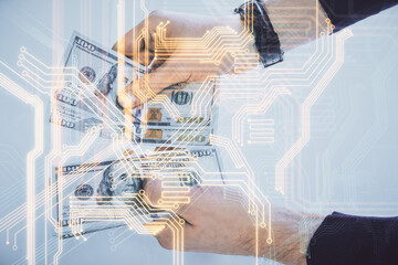 Multi exposure of Tech drawing hologram and USA dollars bills and man hands. Technology concept.