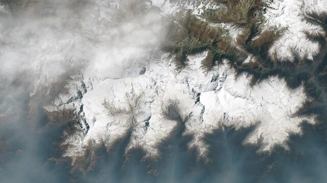 Clouds crossing snowy peaks landscape aerial satellite view of Himalayas mountain range Nepal. Contains images furnished by Nasa