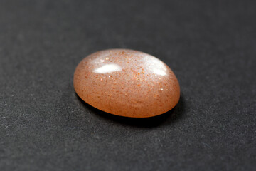 Loose natural oval cabochon sunstone gemstone light peach color with inclusions of hematite and...
