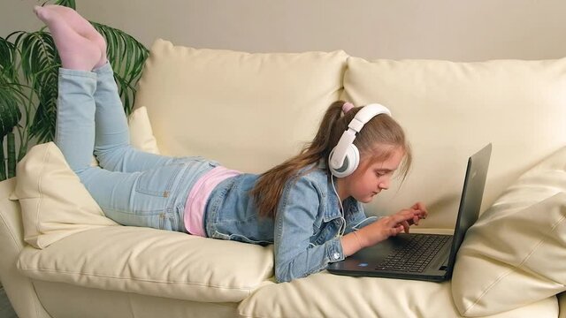 girl with headphones looking video lesson teacher conference laptop sitting