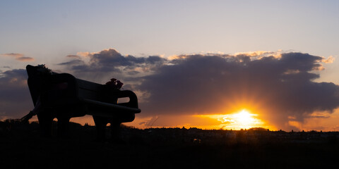 Sunset behind a bench silhouette at Seaton Sluice 