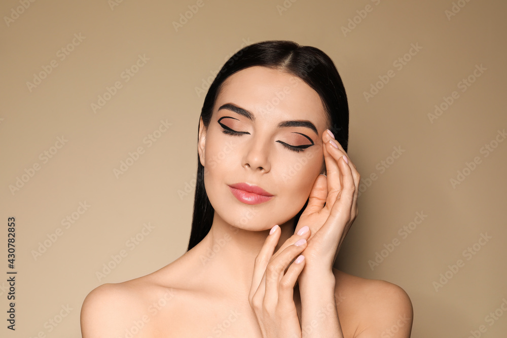 Sticker Beautiful woman with black eyeliner on beige background