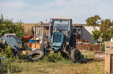 Fototapeta premium a broken tractor stands in the yard in the village, heavy equipment, special equipment