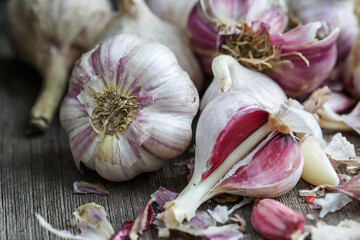 Garlic in burlap. Peeled garlic cloves, garlic bulb on a dark background. Healthy eating concept.