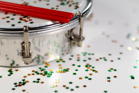 Tamborim. Brazilian instrument of percussion used to play samba used in the carnival. Tambourine and drumstick with colorful confetti, white background. View from tall. Space for text