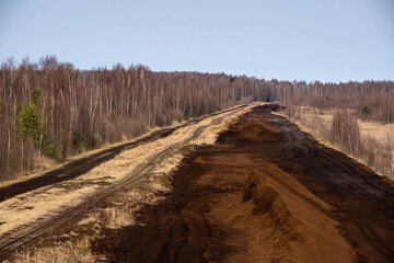 large brown peat piles can be seen in the peat extraction bog.