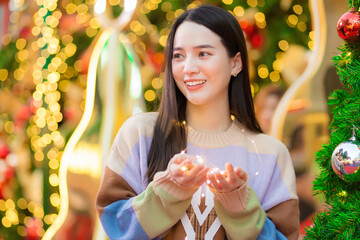 Asian young woman who has long hair lovely smile holding a small light bulb in New Year celebration theme, happiness theme. © nut_foto