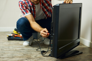 Appliance service. Cropped shot of repairman using a screwdriver while installing or fixing tv set...