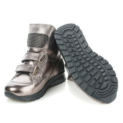 Fashionable bright children's girls' boots and the look of their soles on a white background.