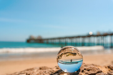 Reflection of the pier on Malibu beach in a spherical ball