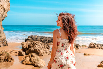 Beautiful woman in dress on Matador Beach near Los Angeles, beautiful rocks and ocean