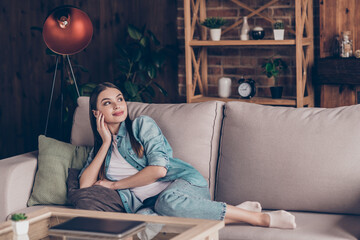 Obraz premium Full length photo of stunning dream young woman look away lie sofa relax weekend inside house apartment