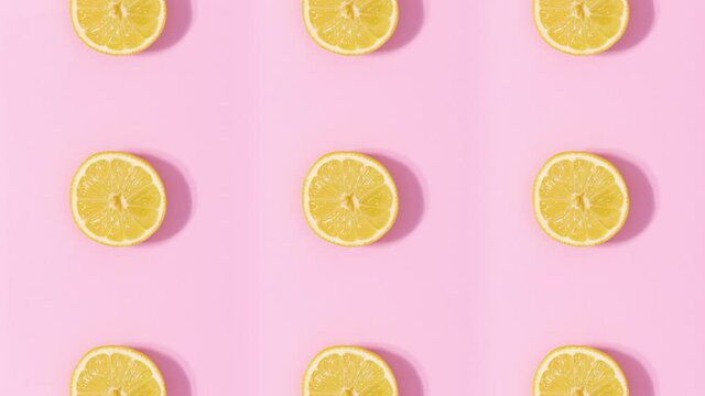Creative pattern made of citrus fruits rotating and changing on pastel pink background. Stop motion